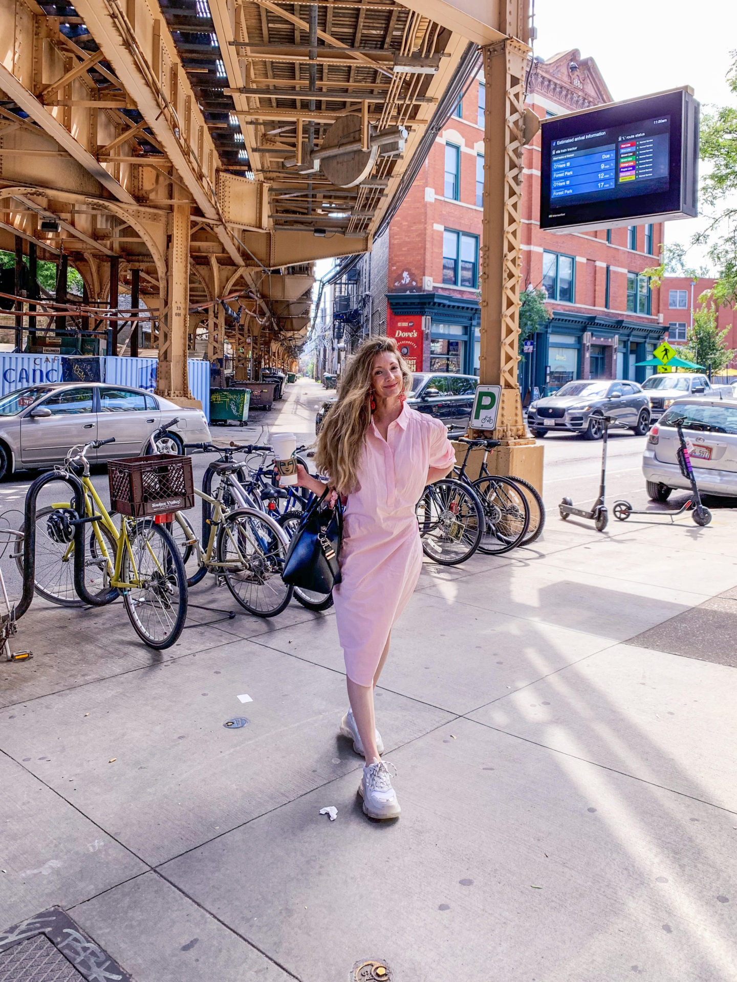 a woman in a pink dress and a city background